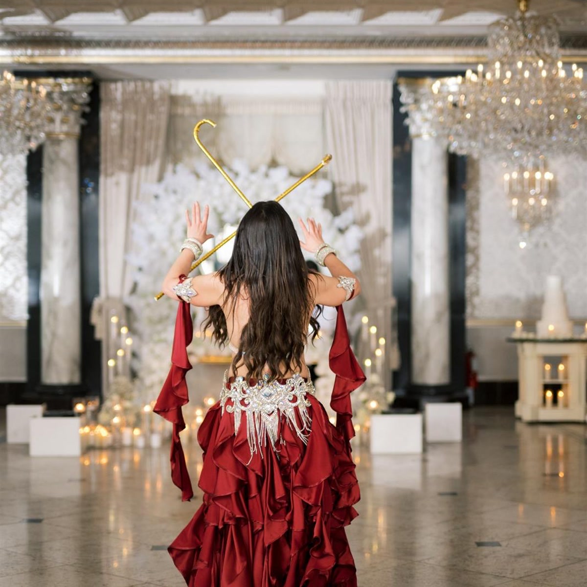 Ivanna performing with crossed golden canes at a wedding celebration