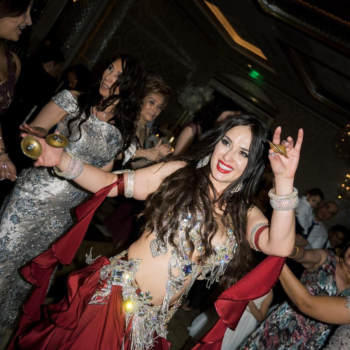 Ivanna performing with finger cymbals in a sparkling silver costume